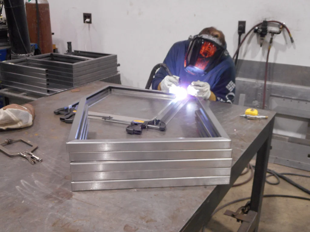 Welder working on a metal assembly from J&J’s gallery